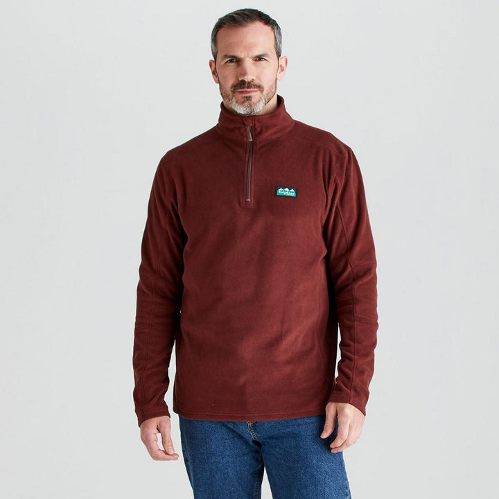 Male model in the burgundy Ridgeline Narvik fleece and blue jeans, front view cropped at the hip, one hand tucked into a pocket.
