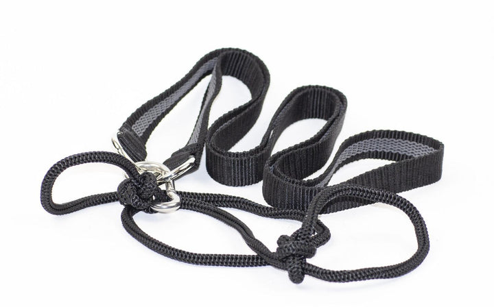 Mjoelner deer carrying strap and drag line, black webbing loops and cord with metal sliders, laid out coiled on white