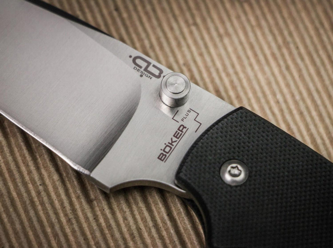 Macro close-up of the Böker Plus XS Drop satin blade with Böker Plus logo and black textured handle