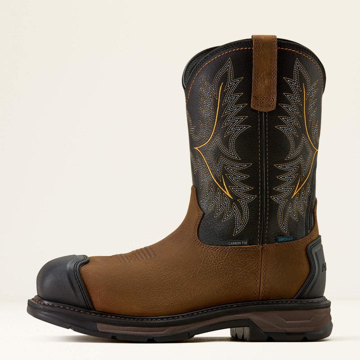 Ariat WorkHog XT in brown and black, side profile showing the protective toe cap, black shaft with yellow stitching and lugged sole
