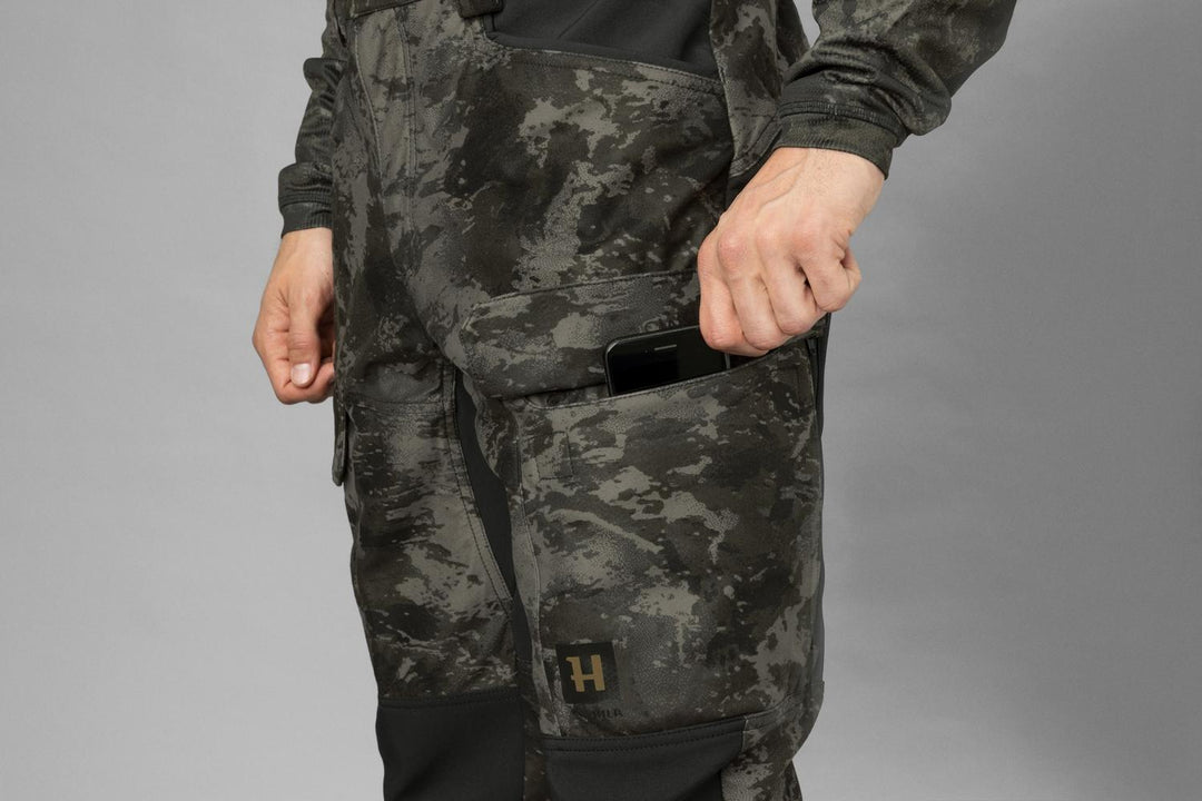 Side detail of a phone slipped into the flapped thigh cargo pocket