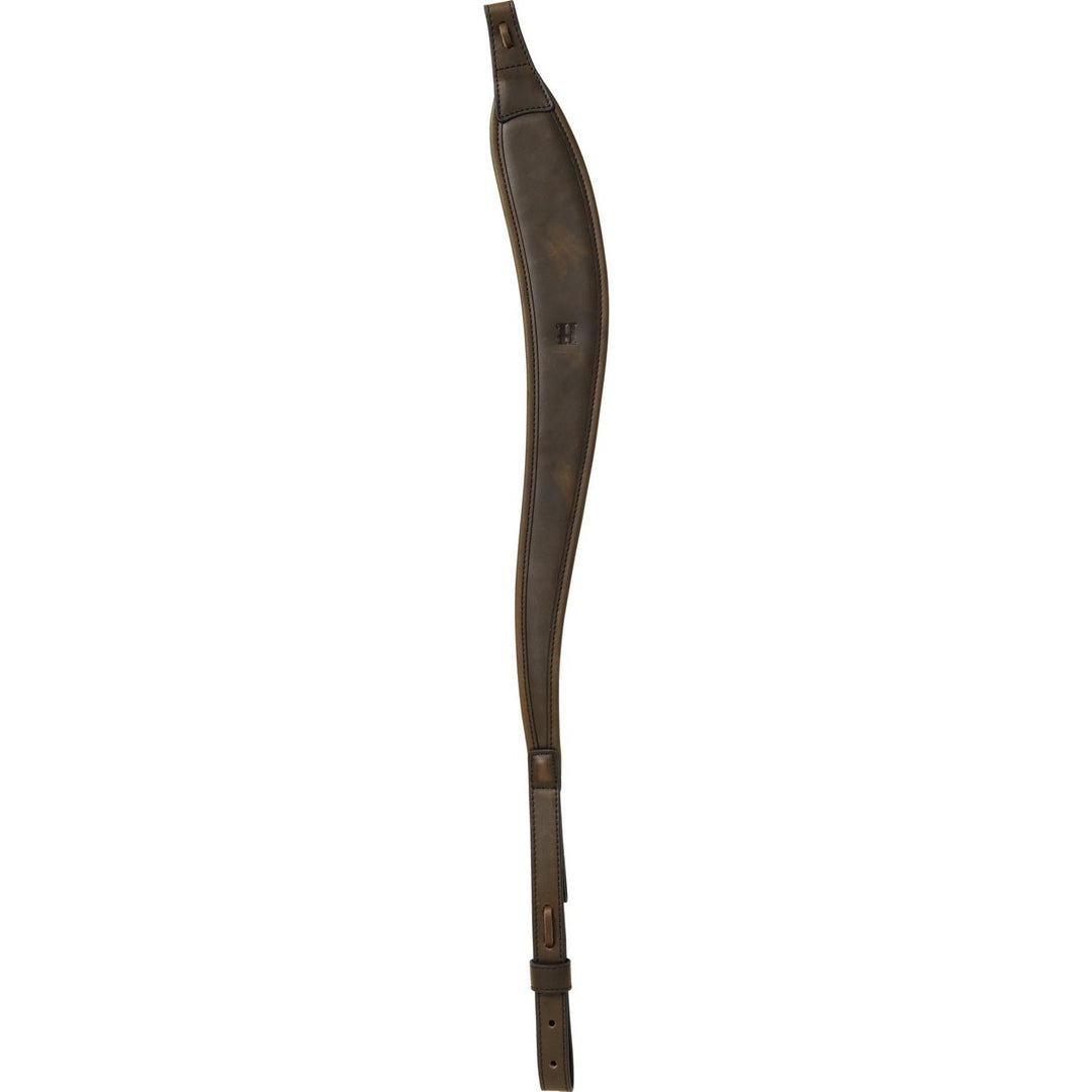 Harkila rifle sling in dark brown leather laid flat, contoured shoulder section with an embossed H mark, stitched edges and a punched buckle tail at the bottom.