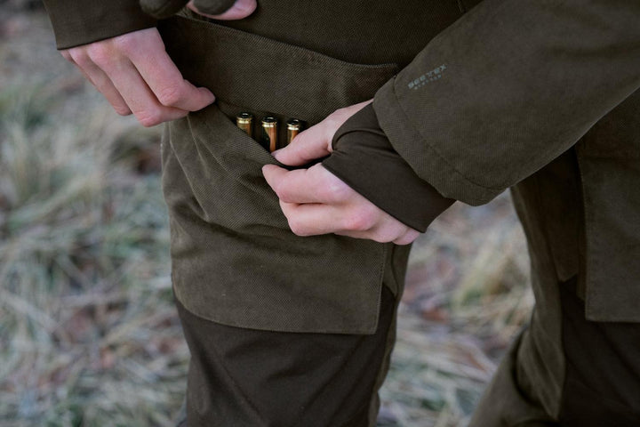 Close-up of a hand loading cartridges into the belt loop holder on the Seeland Helt II trousers