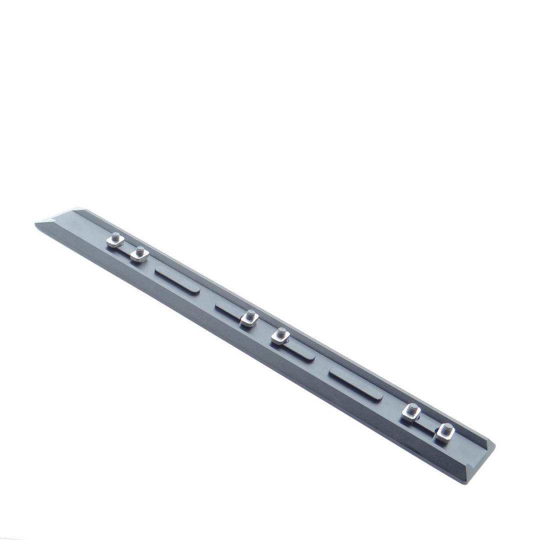 Nieload Tikka TAC A1 ARCA rail laid diagonally, showing the long central slot, mounting hardware and dovetail edges