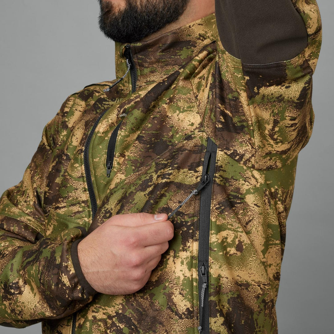 Close-up of a model drawing the chest pocket zip on the Härkila Deer Stalker camo WSP fleece jacket