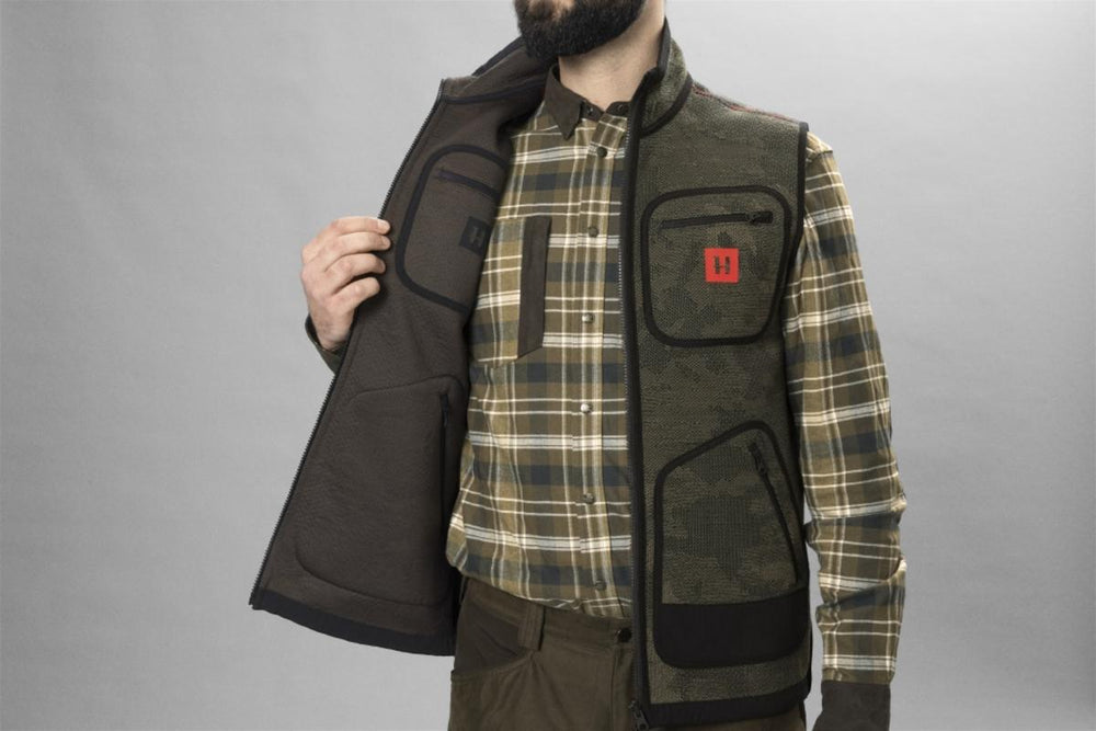 Lifestyle shot of the Harkila Kamko Pro reversible waistcoat worn over a checked shirt