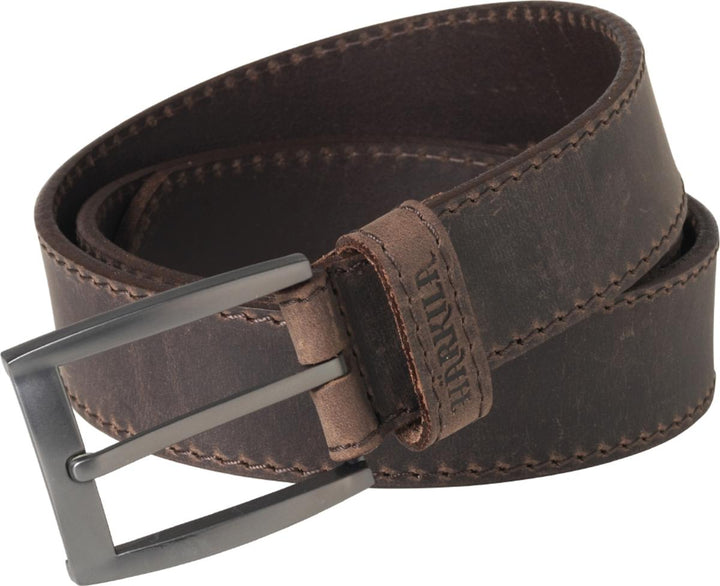 Harkila Arvak belt in dark brown oiled leather coiled on white, gunmetal pin buckle at the left and contrast stitching along both edges.