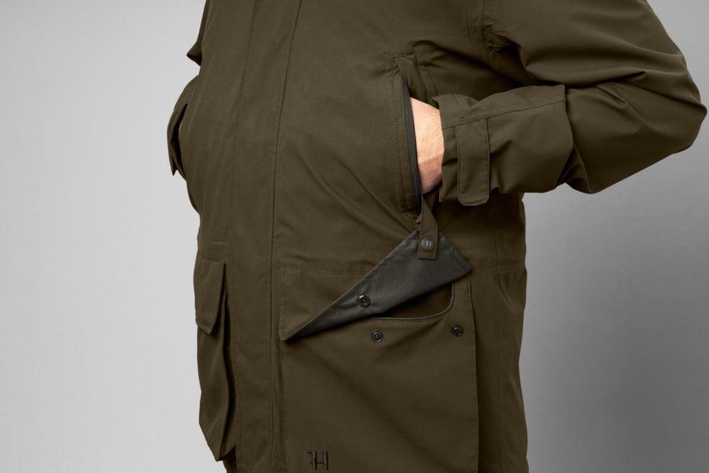 Man accessing a side pocket of the Harkila Orton tech HWS jacket