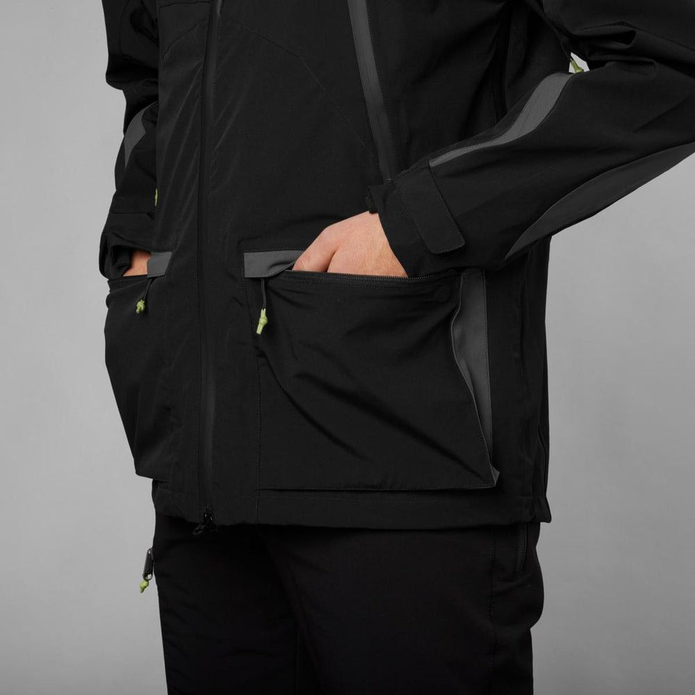 Close-up of the black Dog Active jacket from the side, hands in the hand-warmer pockets and a grey panel running down the sleeve.