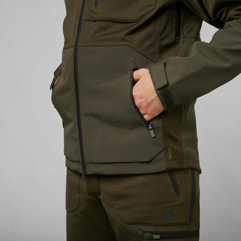 Close-up of a hand in the zipped side pocket of the Seeland Hawker Shell II jacket